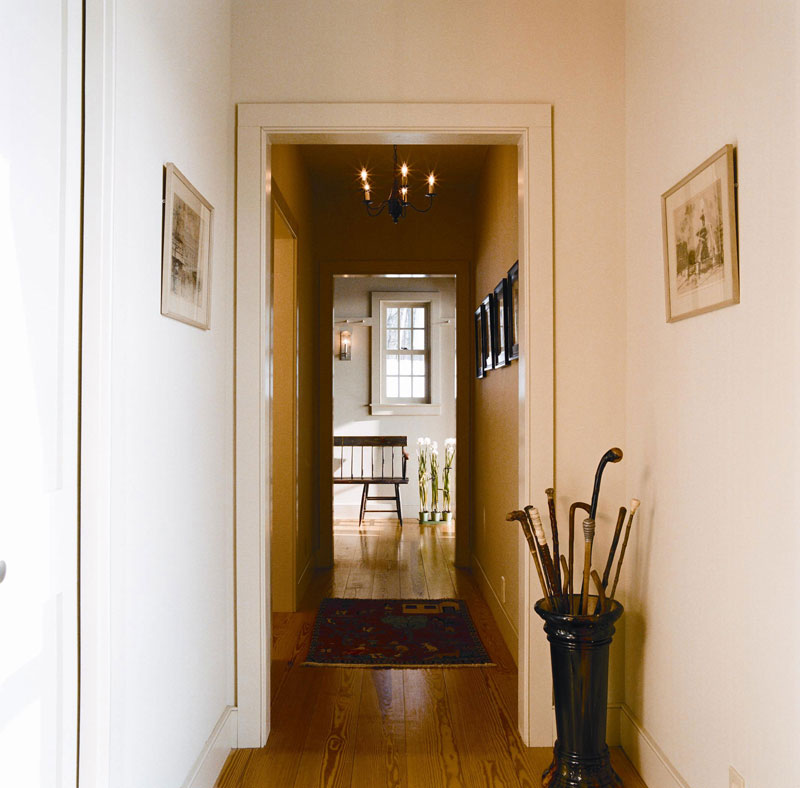 Although the homeowners usually come and go through a mud room off the kitchen, the formal entryway sets the tone for this elegant house. A pottery umbrella stand filled with walking sticks—handy for jaunts through the woods—directs visitors down the corridor to the airy living room.